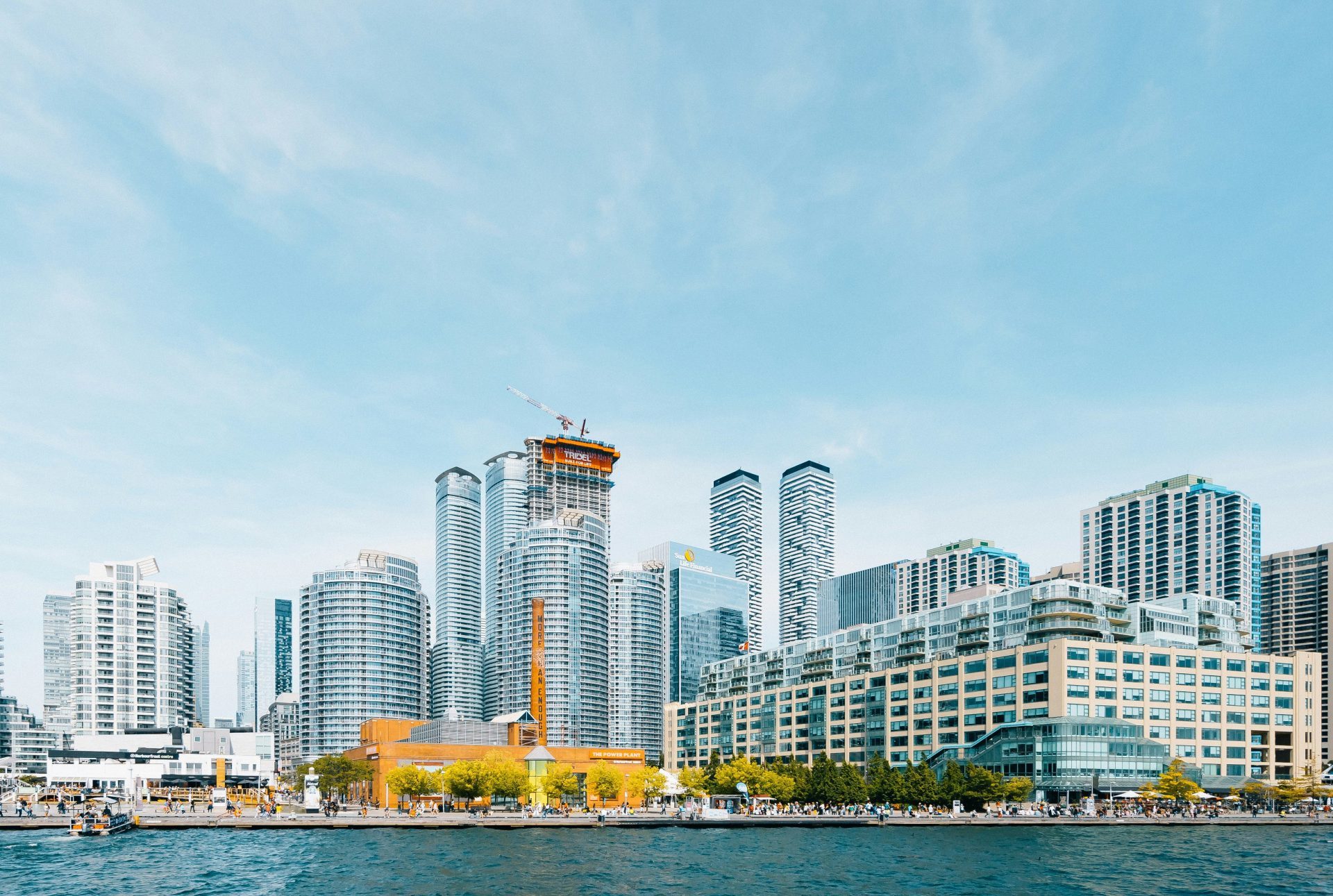body of water near high-rise buildings under blue sky